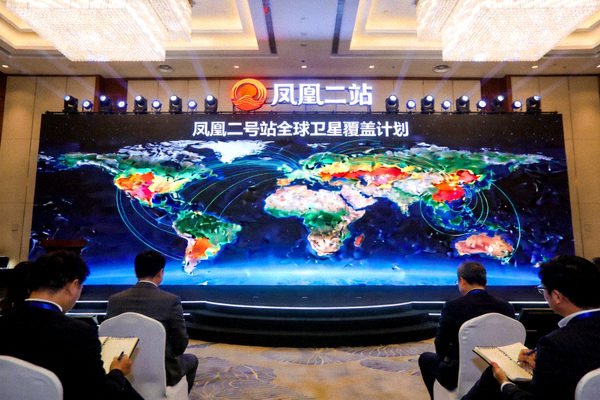 凤凰二号站全球扩张计划发布会现场，大屏幕上显示全球卫星覆盖图